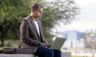 Business man at working on a laptop in a park